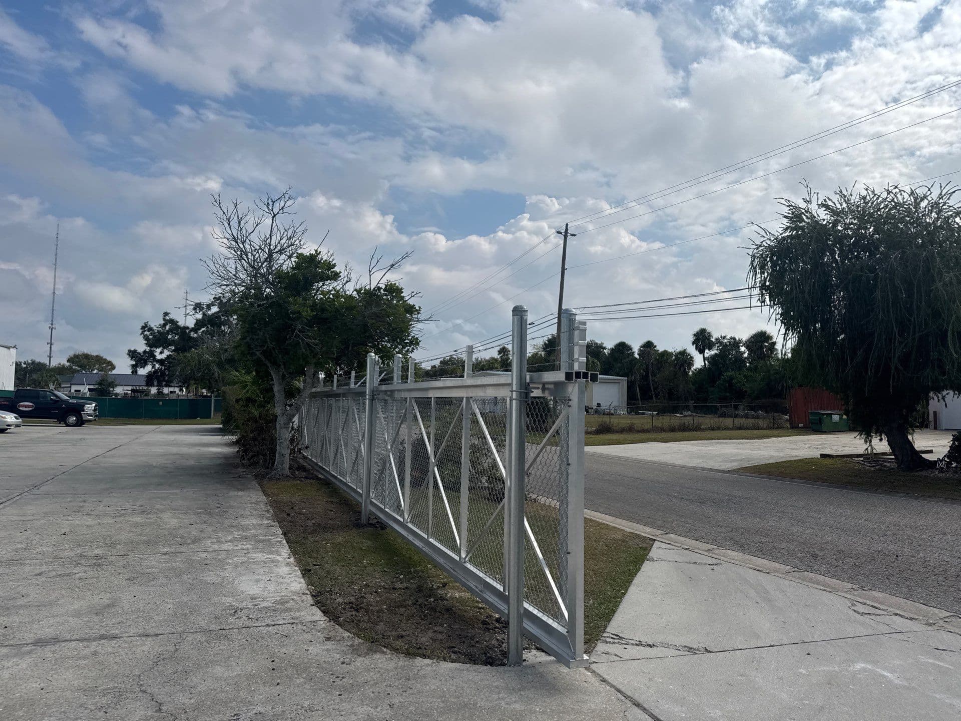 Commercial cantilever driveway gate closed along a chain-link fence, Bradenton–Sarasota–Manatee market