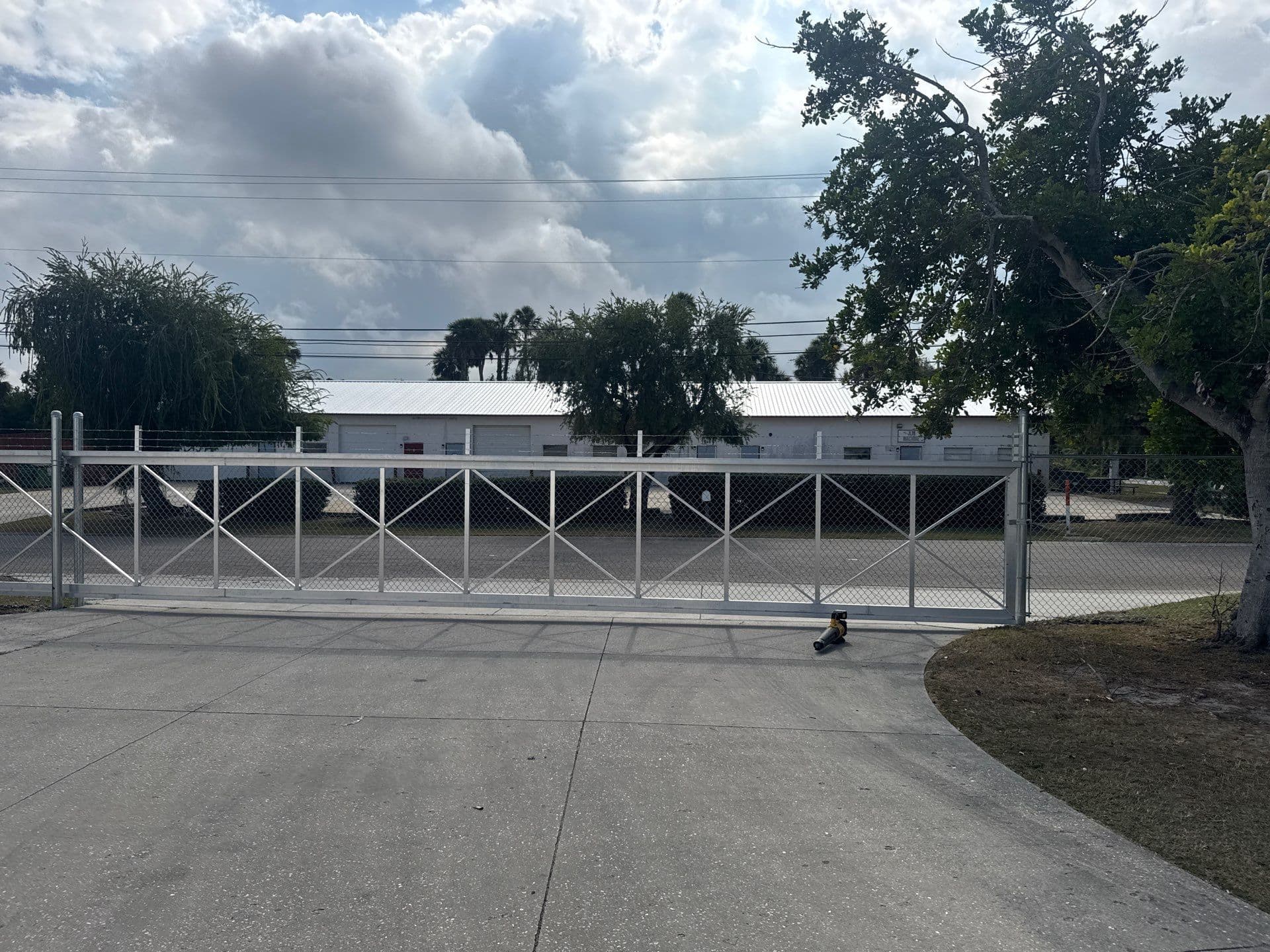 Front view of a commercial cantilever driveway gate across a paved apron